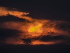Glowing Sun Behind Ominous Clouds